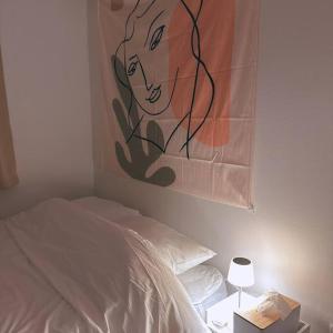 a painting of a woman on the wall next to a bed at Yudama Gangneung in Gangneung