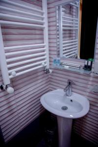 ein Badezimmer mit einem weißen Waschbecken und einem Spiegel in der Unterkunft hostel the moon in Tbilisi City