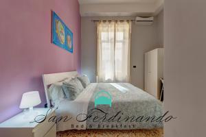 ナポリにあるB&B San Ferdinando Napoliのピンクの壁のベッドルーム1室(窓付)