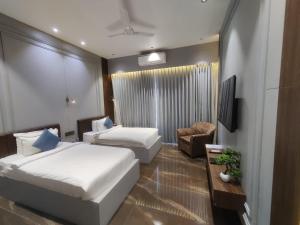 Habitación de hotel con 2 camas y TV en VITS Jamnagar, en Jamnagar