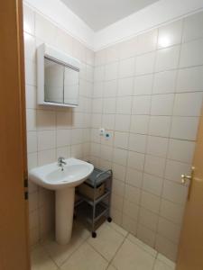 een witte badkamer met een wastafel en een spiegel bij Quinta das Oliveiras 4 Bedrooms with Balcony in Portimão