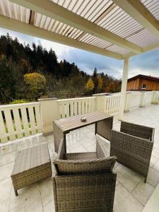 un patio con mesa, sillas y una valla en Tanjas gemütliches Haus am Mondsee en Innerschwand