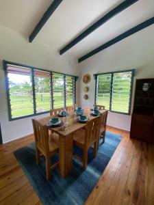 a dining room with a wooden table and chairs at Tobu House in Savusavu