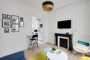 uma sala de estar com um sofá e uma lareira em Aux Clefs des Sacres - Le Chabaud 5 em Reims