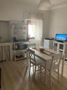 uma cozinha com uma mesa branca e cadeiras num quarto em Residenza “Al Belvedere” em Tolve