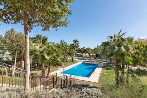a swimming pool in a resort with palm trees at El Oasis Malasia 25 Bajo B in Fuente Alamo