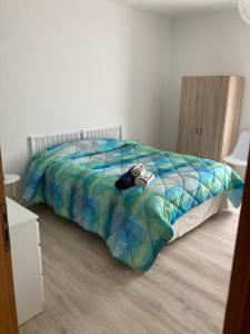 uma cama com um edredão colorido num quarto em Residenza “Al Belvedere” em Tolve