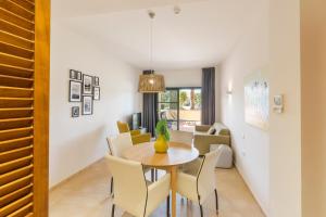 a dining room and living room with a table and chairs at El Oasis Malasia 25 Bajo B in Fuente Alamo