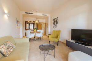 a living room with a couch and a table with chairs at El Oasis Malasia 25 Bajo B in Fuente Alamo