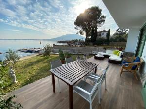 a table and chairs on a deck with a view of the water at Villa Anastasye in Predore