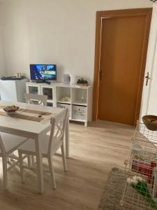 uma sala de estar com uma mesa branca e uma televisão em Residenza “Al Belvedere” em Tolve