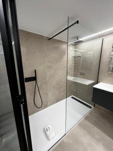 uma casa de banho com uma cabina de duche em vidro e um lavatório. em Dom João Glamour Hotel em Lisboa