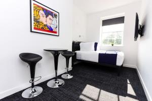 a bedroom with a bed and two black stools at Modern Suite in Fenway Neighborhood in Boston