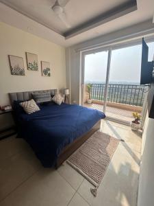 een slaapkamer met een blauw bed en een groot raam bij Peaceful private 1 BHK by Elegance homes in Zirakpur