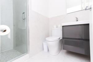 a white bathroom with a toilet and a shower at Modern Suite in Fenway Neighborhood in Boston