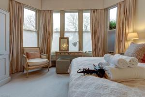 een slaapkamer met een bed met handdoeken en een stoel bij Rawlinson Road 10B in Oxford