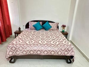 a bedroom with a bed with pink and blue pillows at Guru Mehar in Ludhiana