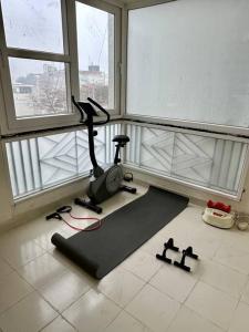 a room with a gym with a treadmill and two windows at Guru Mehar in Ludhiana