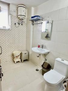 a white bathroom with a toilet and a sink at Guru Mehar in Ludhiana