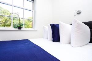 a bedroom with a bed with blue and white pillows at Stylish Studio the Fenway Neighborhood - Unit #106 in Boston