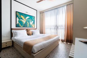 Un dormitorio con una cama grande y una ventana grande. en Studio Vachi , City Centre Location, en Jaipur