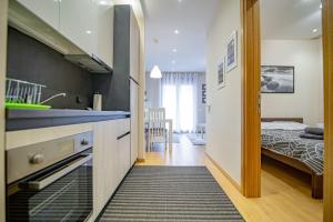 uma cozinha e um quarto com uma cama num quarto em Luxury Kalman Centar Apartmani em Zlatibor