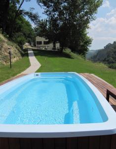a pool on a deck with a view of a house at Podere Riosto Cantina&Agriturismo in Pianoro