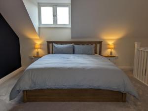 a bedroom with a large bed with two lamps at Stunning Super Kingsize Room - Cheltenham Festival in Cheltenham
