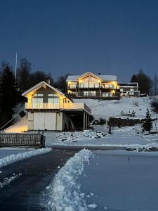 a house in the snow with birds in front of it at Lake house by Storsjön in Östersund