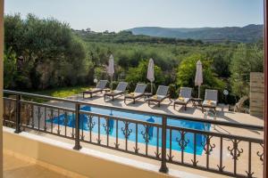 un balcón con una fila de sillas y una piscina en Villa Chrissi, en Kissamos