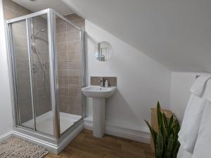 y baño con ducha y lavamanos. en Stunning Super Kingsize Room - Cheltenham Festival, en Cheltenham