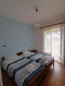 two twin beds in a bedroom with a window at Nikos Apartments in Acharavi
