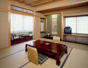 un soggiorno con tavolo e sedie in legno di Hiratakan a Takayama