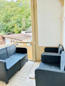 zwei blaue Korbstühle auf einer Veranda mit Aussicht in der Unterkunft Bel appartement proche gare #3 in Bourgoin