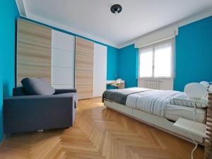 a bedroom with blue walls and a bed and a couch at Echo of the bells in Como