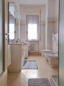 a white bathroom with a sink and a toilet at Echo of the bells in Como