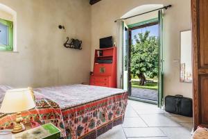 um quarto com uma cama e uma porta de vidro deslizante em Villa Balatella con Piscina by Wonderful Italy em Augusta