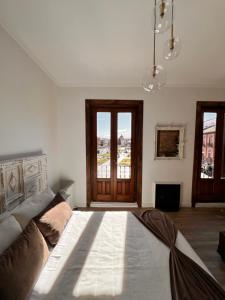 - une chambre avec un lit et une grande fenêtre dans l'établissement Sueña en la Plaza Cervantes, à Alcalá de Henares