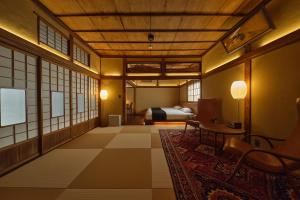una camera d'albergo con letto, tavolo e sedie di Tudzura a Kumamoto