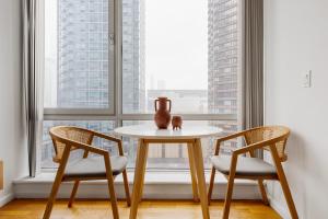 a table and two chairs in front of a window at Blueground Hells Kitchen gym elev nr museum NYC-1434 in New York