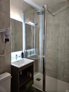 a bathroom with a shower and a sink and a toilet at Hotel Bonanite in Villers-Cotterêts