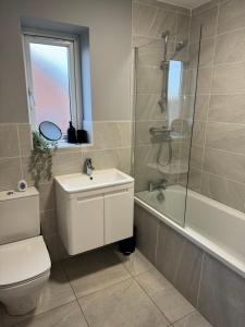 a bathroom with a toilet and a sink and a shower at Lux 3 Bed 10 mins from Centre - Parking & Netflix in Manchester