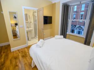 a bedroom with a large white bed and a window at Pass the Keys The Sunny Room at Tavmar Apartments in Lincoln