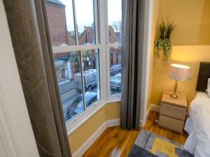 a bedroom with a window with a view of a parking lot at Pass the Keys The Sunny Room at Tavmar Apartments in Lincoln