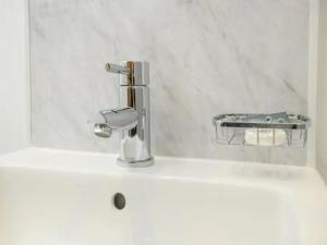 a bathroom sink with a chrome faucet on it at Pass the Keys The Sunny Room at Tavmar Apartments in Lincoln