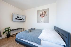 um quarto com uma cama num quarto branco em Modernes Apartment Wels City Center, TG-Stellplatz em Wels