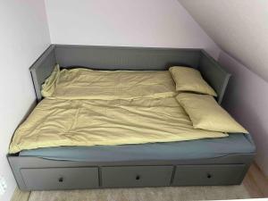 uma cama com lençóis e almofadas amarelas em Small & Cozy Studio Apartment - WiFi & Free Parking em Rapla