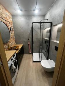 a bathroom with a shower and a toilet and a sink at APARTAMENT z widokiem na stadion. Styl Industrialny . Jedyny TAKI in Poznań