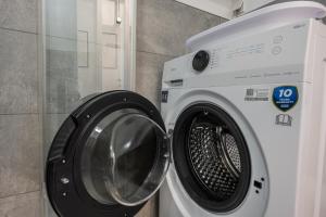 Hay una lavadora junto a una lavadora. en Modernes Apartment Wels City Center, TG-Stellplatz, en Wels