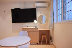 um quarto com uma televisão, uma mesa e uma cadeira em From H Ace Hotel Daejeon by Aank em Daejeon